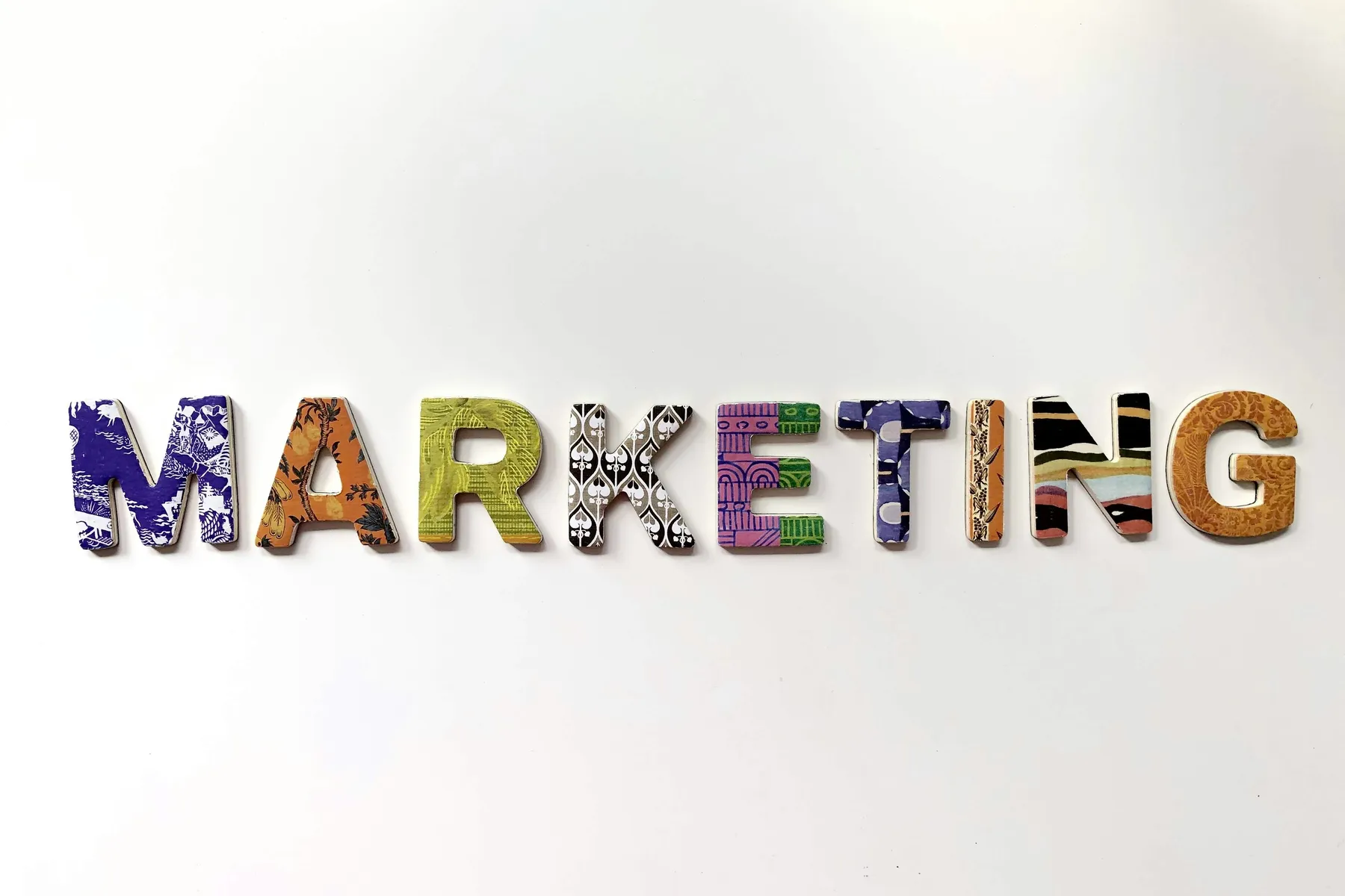 The word marketing assembled from colourful printed materials