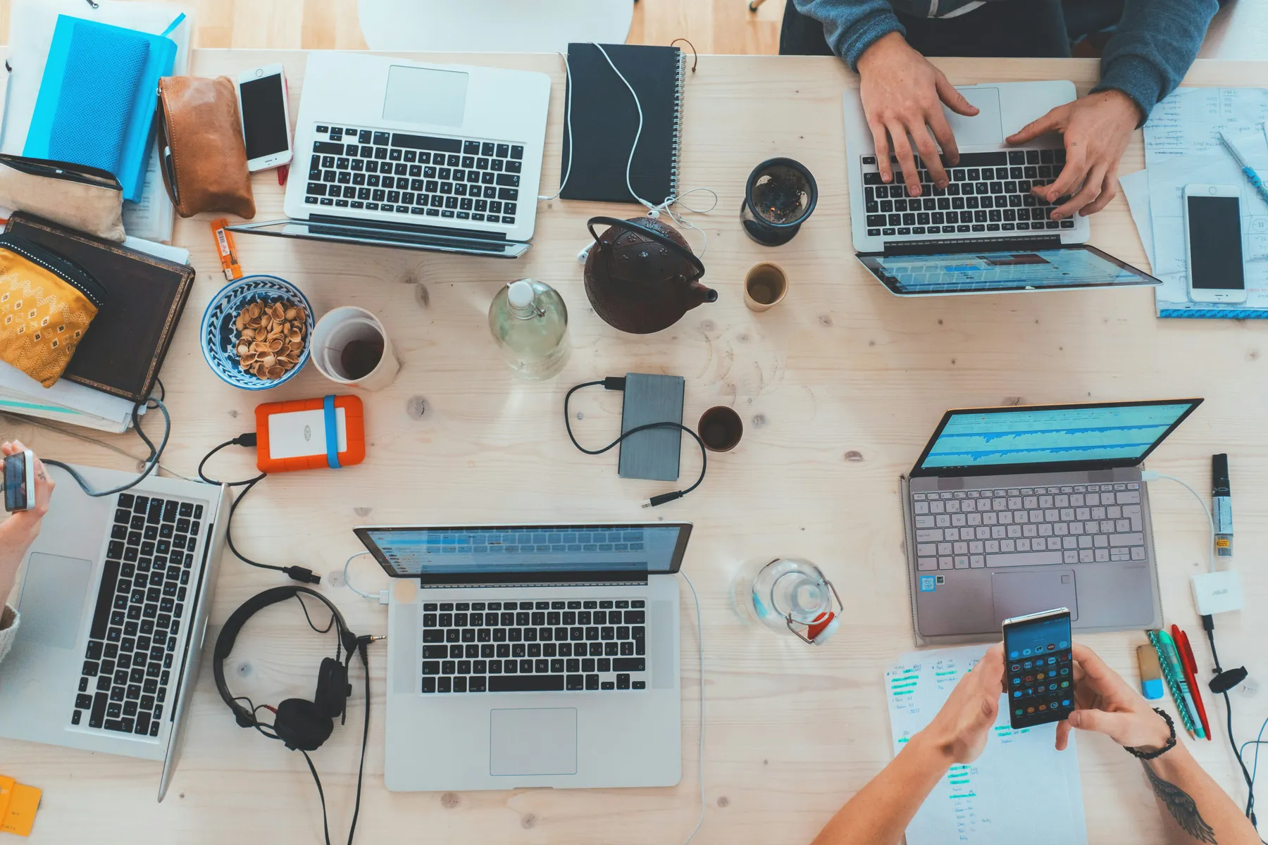 A digital team working across laptops around a shared table